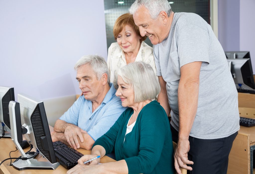 Happy,Senior,People,Using,Computer,Together,In,Class